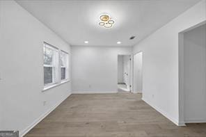 unfurnished room with recessed lighting, wood finished floors, and baseboards