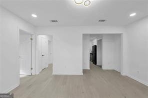 spare room with light wood-style floors, baseboards, and recessed lighting