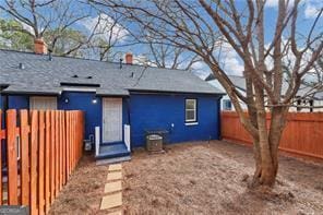 rear view of property featuring cooling unit and a fenced backyard