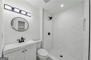 bathroom with toilet, a shower stall, visible vents, and vanity