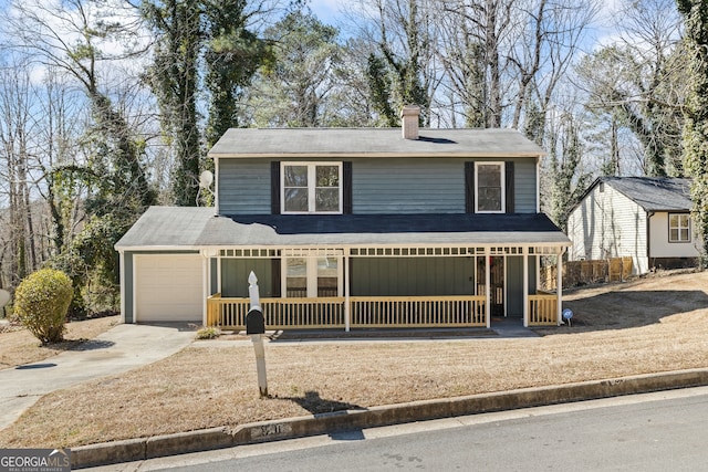 traditional-style house with covered porch, driveway, a chimney, and an attached garage