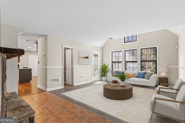 living area featuring lofted ceiling, visible vents, and wood finished floors