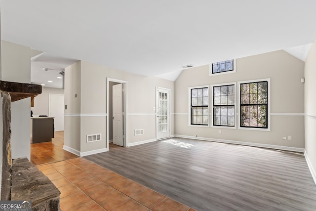 unfurnished living room with lofted ceiling, visible vents, and wood finished floors