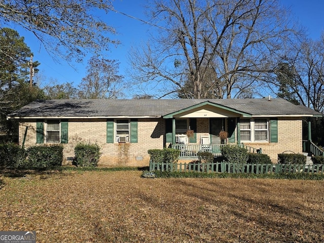 ranch-style house with brick siding, crawl space, cooling unit, and a fenced front yard