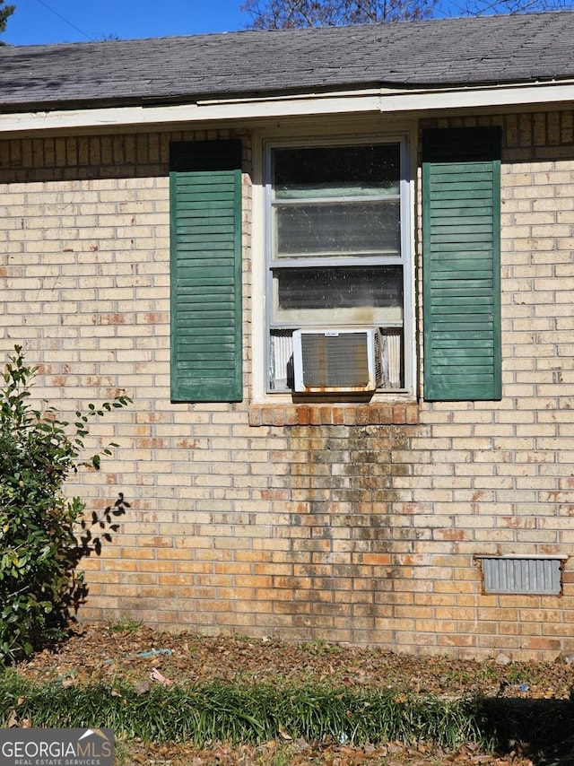 view of side of property featuring crawl space, brick siding, roof with shingles, and cooling unit