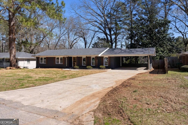 ranch-style home featuring a carport, concrete driveway, fence, and a front lawn