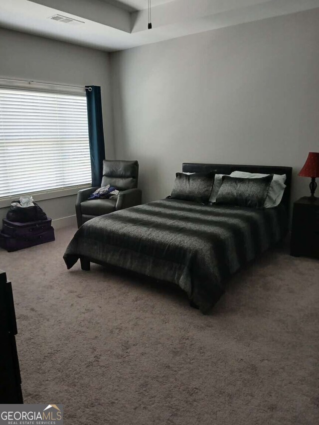 carpeted bedroom featuring visible vents