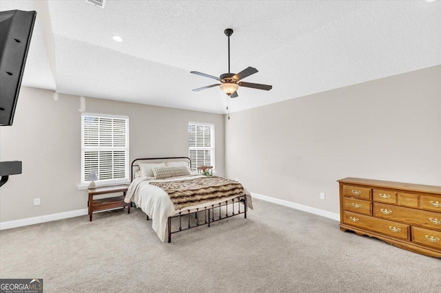 bedroom with light colored carpet, a textured ceiling, and baseboards