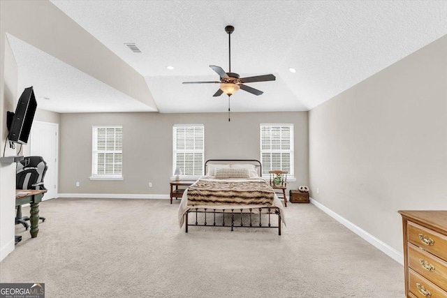 bedroom with lofted ceiling, light colored carpet, visible vents, multiple windows, and baseboards