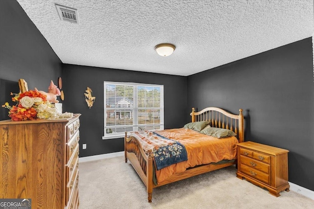 bedroom featuring light colored carpet, visible vents, a textured ceiling, and baseboards