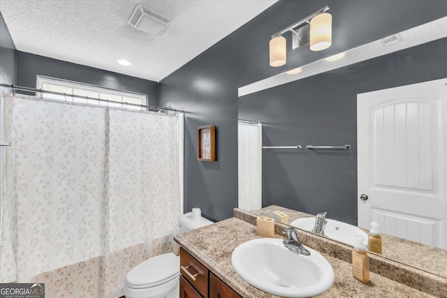 bathroom with a textured ceiling, toilet, a shower with shower curtain, vanity, and visible vents