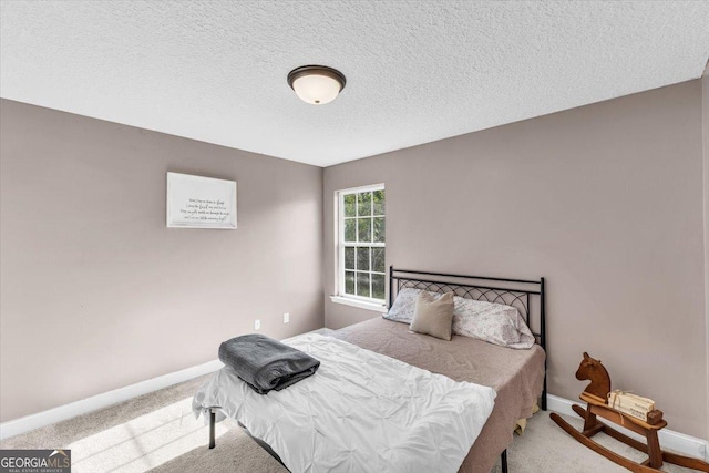 carpeted bedroom with a textured ceiling and baseboards