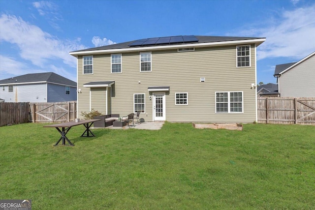 732 Waterlily Ct, Hinesville, GA 31313 - back of house with roof mounted solar panels, a patio, a lawn, an outdoor living space, and a fenced backyard