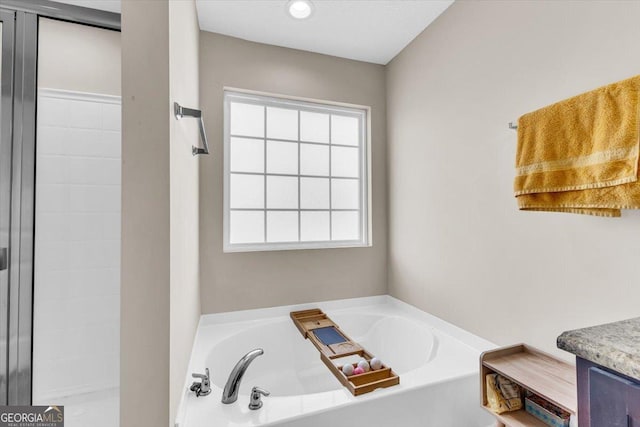 bathroom featuring vanity and a bath