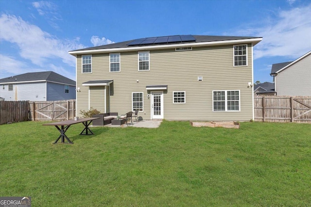 rear view of house with solar panels, a patio, a fenced backyard, an outdoor hangout area, and a yard