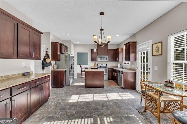 732 Waterlily Ct, Hinesville, GA 31313 - kitchen with stone finish floor, a sink, appliances with stainless steel finishes, a kitchen island, and a notable chandelier