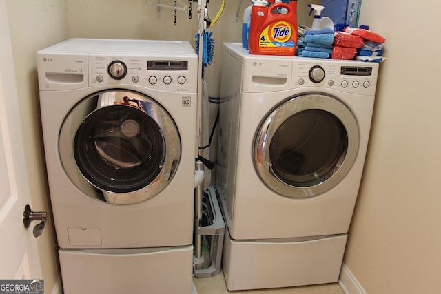 laundry room with laundry area, washer and clothes dryer, and baseboards