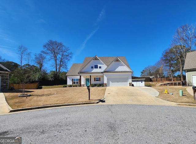 view of front of house with a garage, concrete driveway, fence, and stone siding