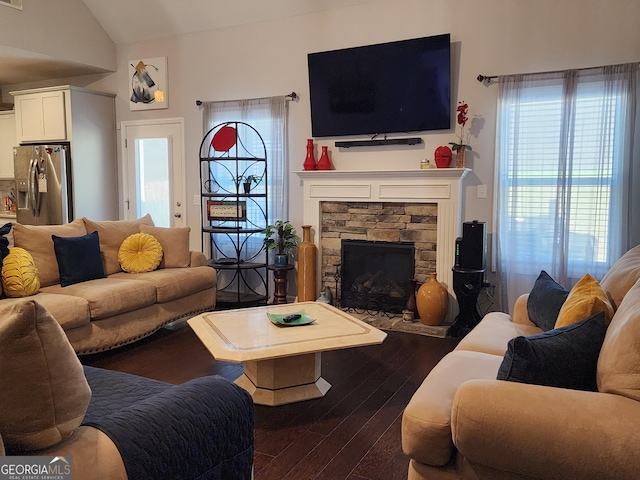 living area with lofted ceiling, a fireplace, visible vents, and dark wood finished floors