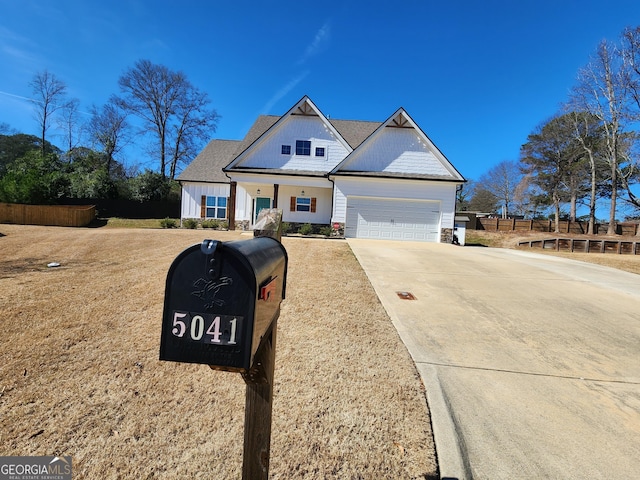 view of front of home with a garage, board and batten siding, fence, and concrete driveway