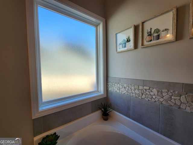 bathroom with a garden tub and plenty of natural light