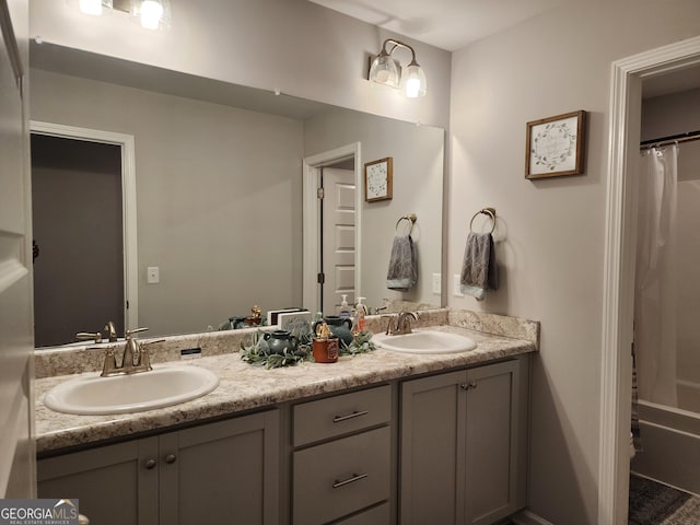 bathroom with shower / bath combination with curtain, a sink, and double vanity