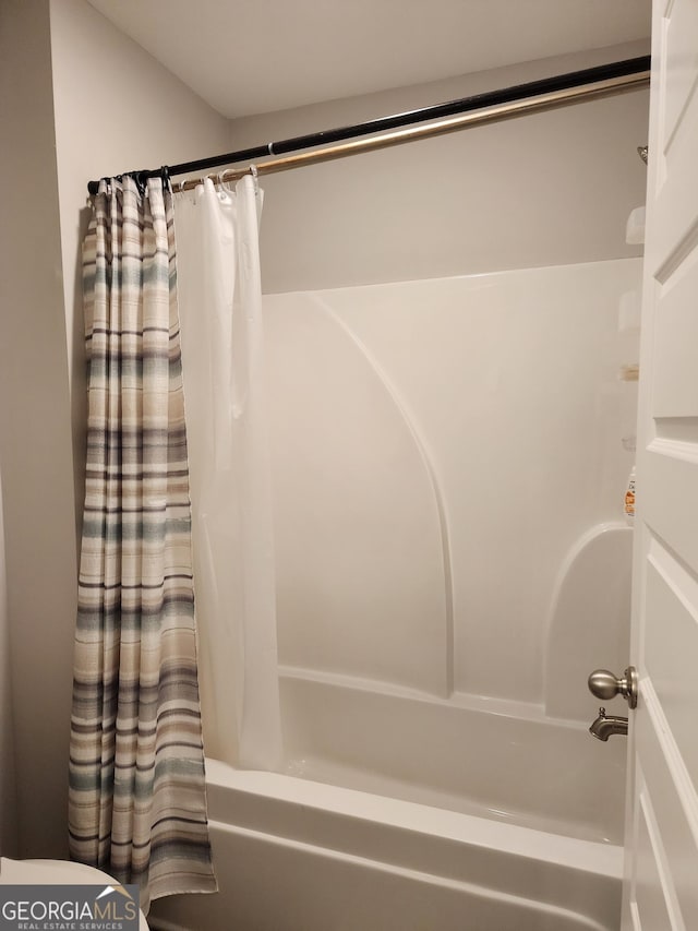 bathroom with shower / bath combo with shower curtain