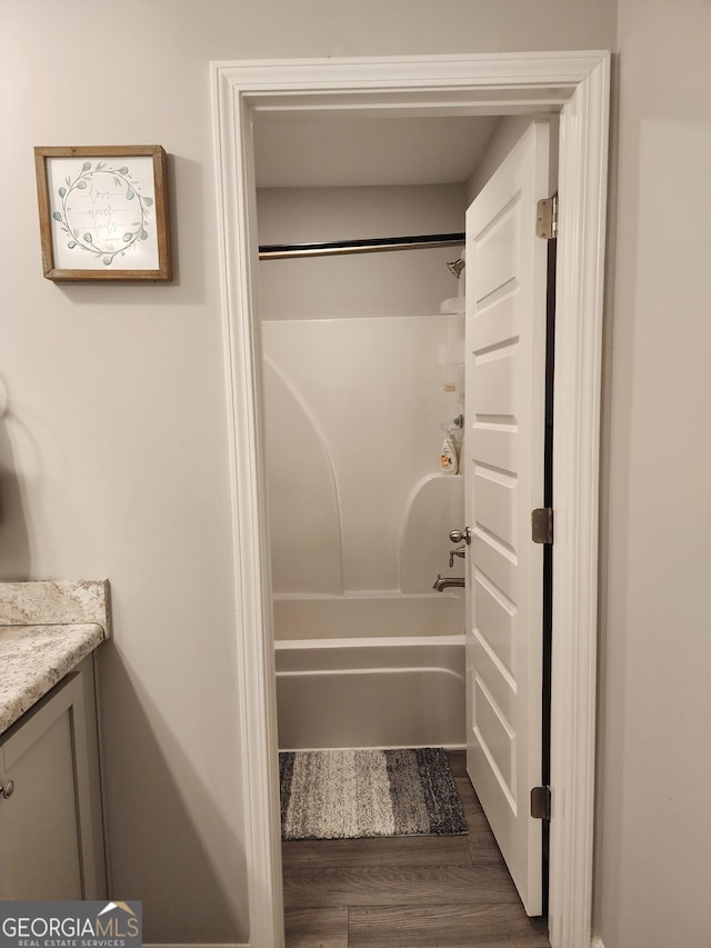 full bath featuring  shower combination, wood finished floors, and vanity