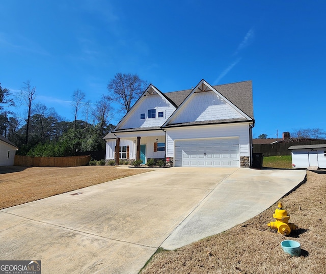 view of front facade with a garage, covered porch, fence, concrete driveway, and a front lawn