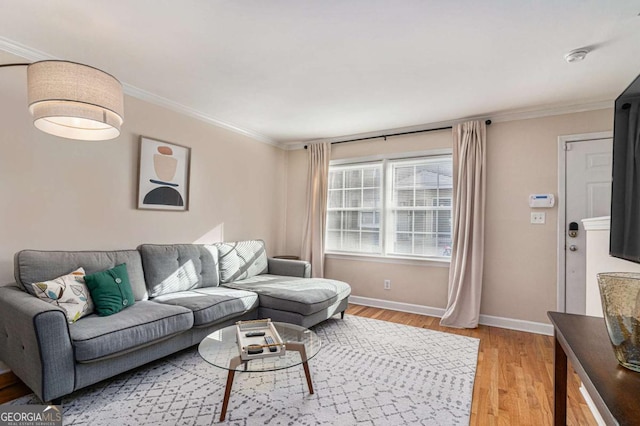 living room featuring ornamental molding, light wood-style flooring, and baseboards