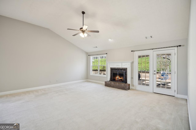 unfurnished living room with lofted ceiling, light carpet, a fireplace, and baseboards