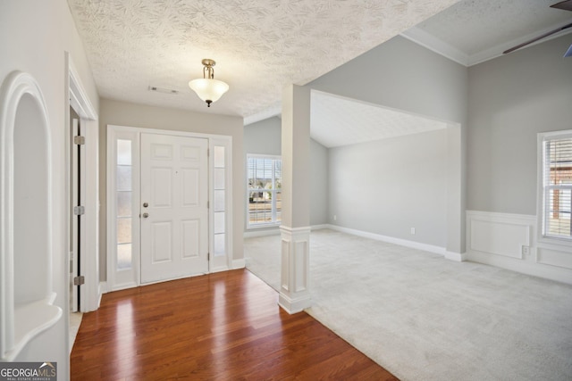 foyer entrance featuring plenty of natural light, a textured ceiling, and wood finished floors