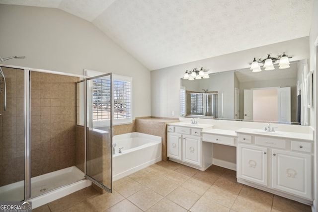 full bath featuring vaulted ceiling, tile patterned flooring, a sink, and a bath