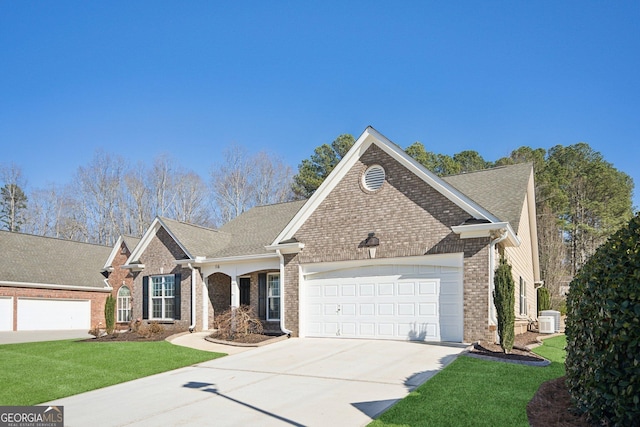 view of front of home featuring a garage, brick siding, concrete driveway, central air condition unit, and a front yard