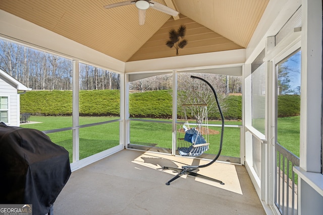 sunroom with a ceiling fan, a wealth of natural light, and vaulted ceiling