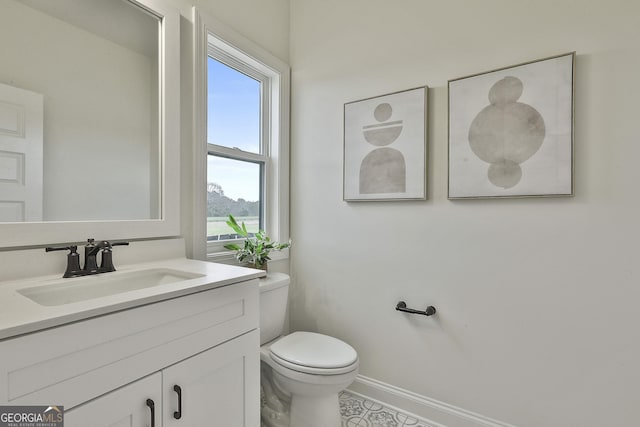 bathroom featuring baseboards, vanity, and toilet