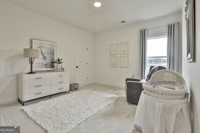 sitting room with light colored carpet, visible vents, and baseboards