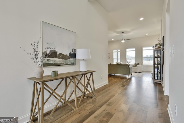 hallway featuring recessed lighting, baseboards, and wood finished floors