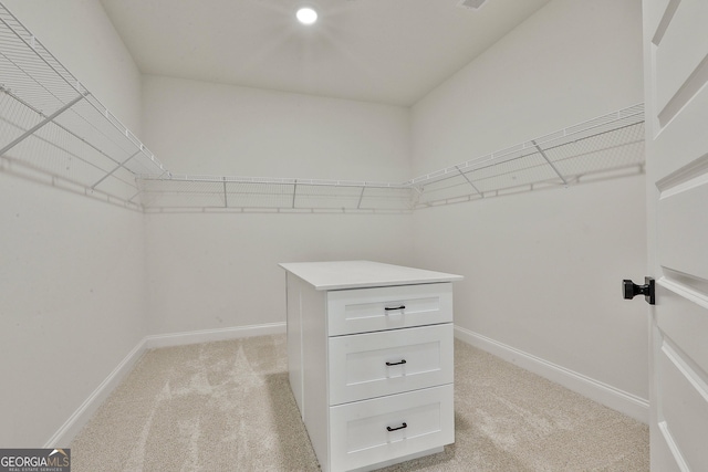 walk in closet featuring light carpet