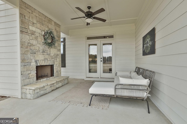 view of patio / terrace with a large fireplace, ceiling fan, and french doors