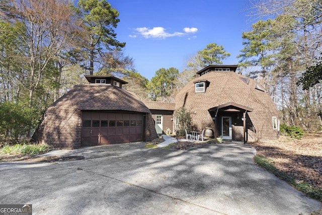 view of front of property with driveway, a garage, and roof with shingles