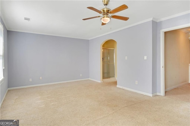 empty room with light carpet, visible vents, arched walkways, baseboards, and ornamental molding