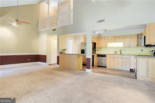 kitchen featuring visible vents, stainless steel appliances, open floor plan, and glass insert cabinets