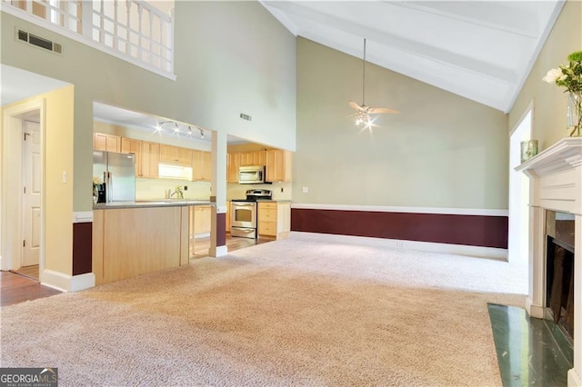 unfurnished living room featuring ceiling fan, light colored carpet, a fireplace with flush hearth, visible vents, and baseboards