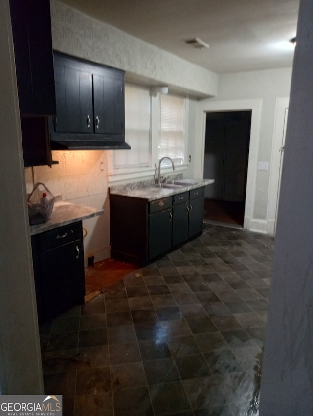 kitchen with baseboards, light countertops, and a sink