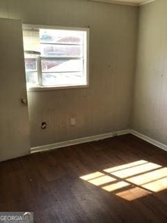 spare room with dark wood finished floors and baseboards