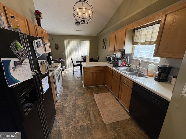 kitchen featuring decorative light fixtures, light countertops, a sink, a peninsula, and black appliances