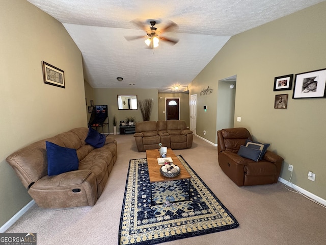 living room with lofted ceiling, a textured ceiling, ceiling fan, carpet floors, and baseboards