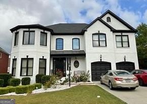 view of front of home with aphalt driveway, a front lawn, and a garage