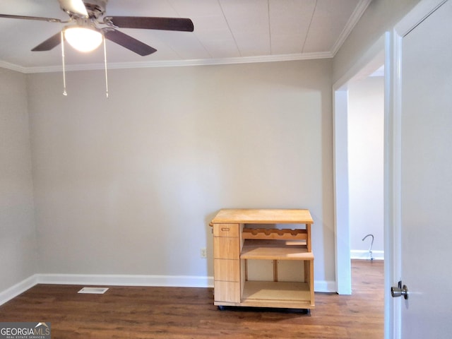 interior space with baseboards, ceiling fan, dark wood-style flooring, and crown molding